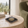 earth-tempo-reading Earth Tempo gold spiral device on a travertine table beside an olive reading chair